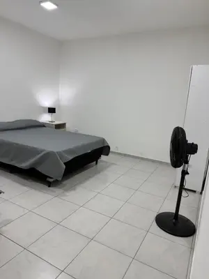 a bedroom with a bed and a black fan at Departamentos Mi Cielo in Villa Cura Brochero