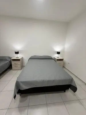 a bedroom with a bed and two night stands at Departamentos Mi Cielo in Villa Cura Brochero