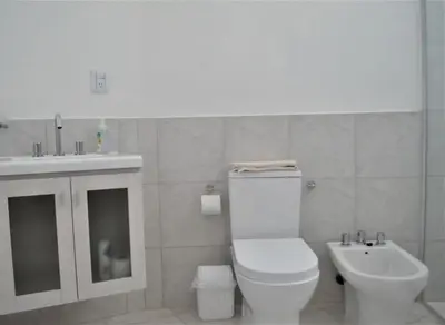 a white bathroom with a toilet and a sink at RM Dpto a pocas cuadras del centro in Villa Carlos Paz