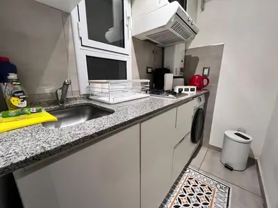 a kitchen with a sink and a washing machine at Departamento para 3 personas Zona Nueva Córdoba in Cordoba