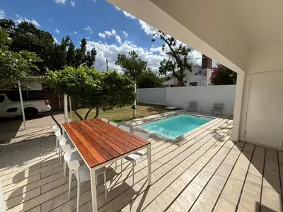 a patio with a table and a swimming pool at Casa Jorge Newbery in Villa Carlos Paz