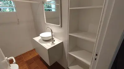 a white bathroom with a sink and a mirror at Casa Jorge Newbery in Villa Carlos Paz