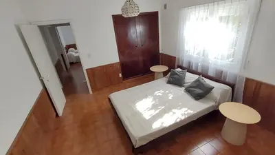 a bedroom with a bed and two tables and a window at Casa Jorge Newbery in Villa Carlos Paz