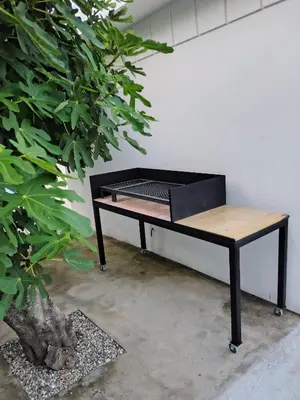 a black desk with a wooden top next to a plant at Casa Jorge Newbery in Villa Carlos Paz
