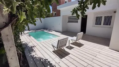 a patio with two chairs and a swimming pool at Casa Jorge Newbery in Villa Carlos Paz