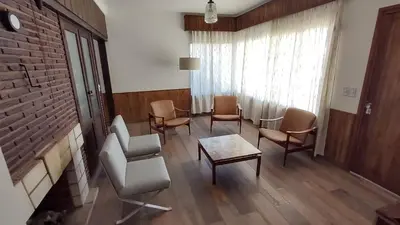 a waiting room with chairs and a table and a brick wall at Casa Jorge Newbery in Villa Carlos Paz