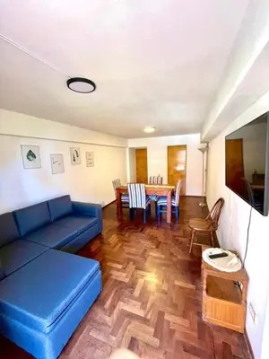 a living room with a blue couch and a table at Departamento amplio 4 personas Zona Nueva Córdoba in Cordoba