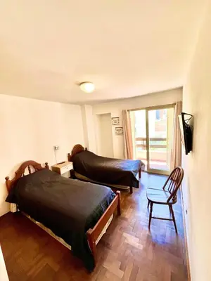 a bedroom with two beds and a living room at Departamento amplio 4 personas Zona Nueva Córdoba in Cordoba
