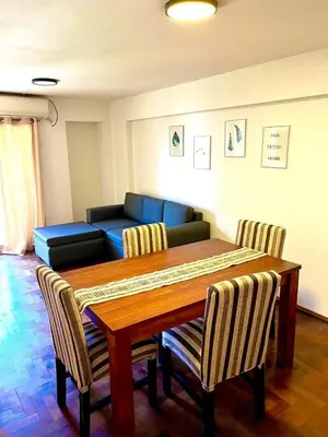 a living room with a table and a couch at Departamento amplio 4 personas Zona Nueva Córdoba in Cordoba