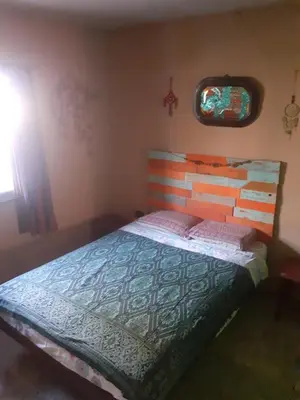 a bedroom with a bed with a wooden headboard and a window at Latido de Montaña in Bialet Massé