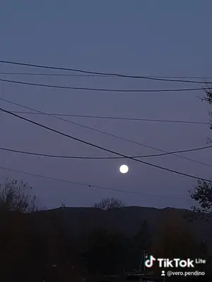 a moon sitting on top of some power lines at Latido de Montaña in Bialet Massé