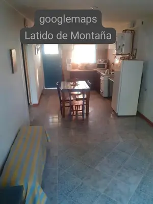 a kitchen and dining room with a table and a refrigerator at Latido de Montaña in Bialet Massé
