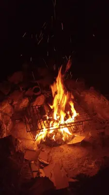 a fire is burning in the dirt at night at Latido de Montaña in Bialet Massé
