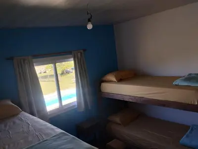 a bedroom with two bunk beds and a window at Cabaña gio in Potrero de Garay