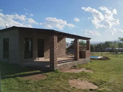 a small brick house with a roof on a field at Cabaña gio in Potrero de Garay