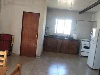 a kitchen with a white refrigerator and a wooden door at Cabaña gio in Potrero de Garay