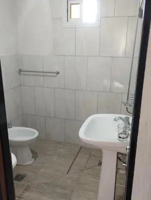 a white bathroom with a sink and a toilet at Cabaña gio in Potrero de Garay