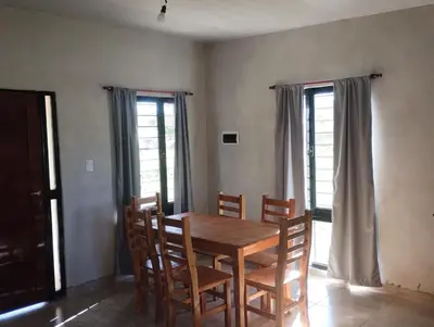 a dining room with a wooden table and chairs at Cabaña gio in Potrero de Garay