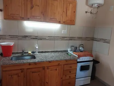 a kitchen with a sink and a stove at Cabañas San Antonio in Santa Rosa de Calamuchita