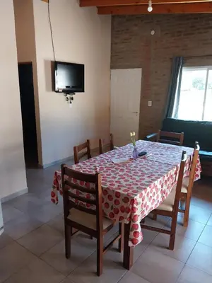 a dining room table with a red and white table cloth at Cabañas San Antonio in Santa Rosa de Calamuchita