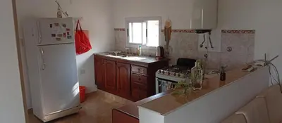 a kitchen with a white refrigerator and a stove at La Casita De Mabel in Villa Santa Cruz del Lago