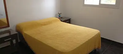 a yellow blanket on a bed in a room at La Casita De Mabel in Villa Santa Cruz del Lago