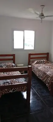 two beds in a room with two windows at La Casita De Mabel in Villa Santa Cruz del Lago