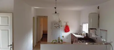 a white kitchen with a stove and a refrigerator at La Casita De Mabel in Villa Santa Cruz del Lago