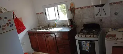 a small kitchen with a stove and a sink at La Casita De Mabel in Villa Santa Cruz del Lago