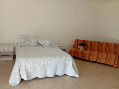 a bedroom with a bed and a couch at Casa en sierras de cordoba in San Roque
