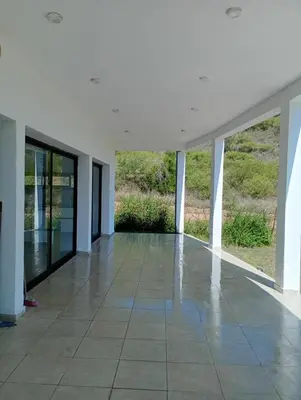 an empty room with glass doors and a tiled floor at Casa en sierras de cordoba in San Roque