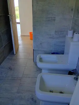 a bathroom with a toilet and a sink at Casa en sierras de cordoba in San Roque