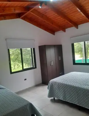 a bedroom with two beds and two windows at Los Peranzzi-Casa Serrana in Los Reartes