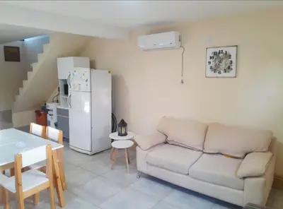 a living room with a couch and a refrigerator at Los Peranzzi-Casa Serrana in Los Reartes