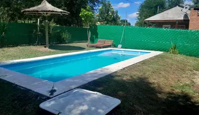 a swimming pool in a yard with a bench and a fence at Los Peranzzi-Casa Serrana in Los Reartes