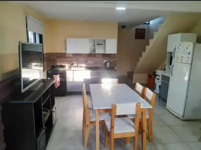 a kitchen with a table and chairs and a refrigerator at Los Peranzzi-Casa Serrana in Los Reartes