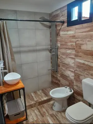 a bathroom with a shower with a toilet and a sink at Los Peranzzi-Casa Serrana in Los Reartes