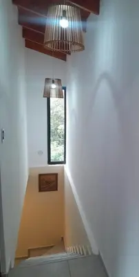 a staircase in a house with two lights and a window at Los Peranzzi-Casa Serrana in Los Reartes