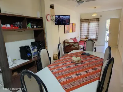 a dining room with a table with chairs and a room with a couch at Marcelina in Villa Carlos Paz