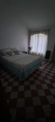 a bedroom with a bed and a checkered floor at Complejo La Paz in Villa Carlos Paz