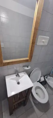a bathroom with a sink and a toilet and a mirror at Complejo La Paz in Villa Carlos Paz