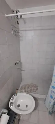 a white bathroom with a toilet and a sink at Complejo La Paz in Villa Carlos Paz