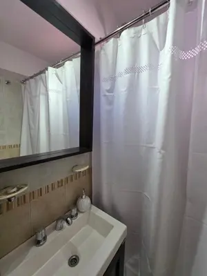 a bathroom with a white shower curtain and a sink at Vissia Cba in Cordoba