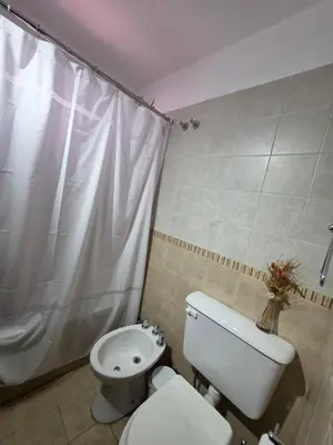 a bathroom with a toilet and a shower curtain at Vissia Cba in Cordoba