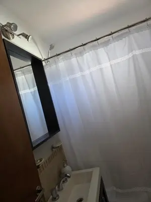 a bathroom with a white shower curtain and a sink at Vissia Cba in Cordoba