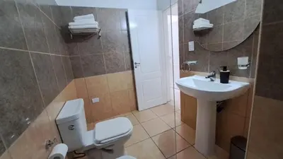 a bathroom with a white toilet and a sink at Dpto a estrenar Asador Pileta Cochera propia Terraza privada con vista a sierras Seguridad 24 hs Av Colón Alberdi Ubicación estratégica H Clínicas Kempes Shopping Carlos Paz in Cordoba