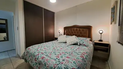 a bedroom with a bed and two lamps on tables at Dpto a estrenar Asador Pileta Cochera propia Terraza privada con vista a sierras Seguridad 24 hs Av Colón Alberdi Ubicación estratégica H Clínicas Kempes Shopping Carlos Paz in Cordoba
