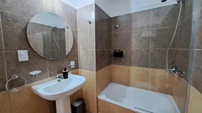 a bathroom with a sink and a tub and a mirror at Dpto a estrenar Asador Pileta Cochera propia Terraza privada con vista a sierras Seguridad 24 hs Av Colón Alberdi Ubicación estratégica H Clínicas Kempes Shopping Carlos Paz in Cordoba