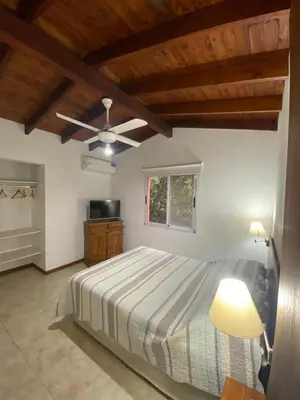 a bedroom with a bed and a ceiling fan at Casa terracota in Villa General Belgrano