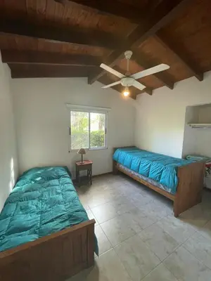 a bedroom with two beds and a ceiling fan at Casa terracota in Villa General Belgrano